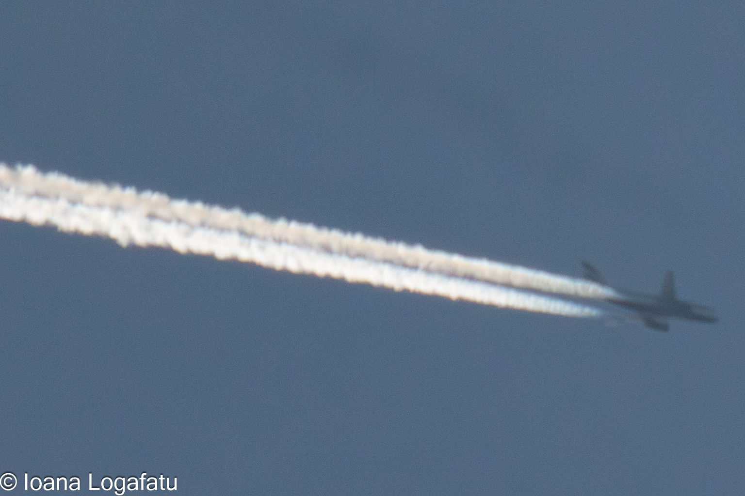Contrails painting the sky above a bustling city